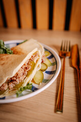 Close-up view of savory crepes filled with meat, pickles and lettuce on plate. Warm tones, shallow depth of field and natural food styling.