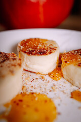 Close-up of cottage cheese pancakes topped with fruit sauce and crumbs. Soft warm light, shallow depth of field and cozy homemade dessert aesthetic