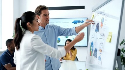 Diverse business professionals collaborating on whiteboard, discussing strategy in modern office. - Powered by Adobe