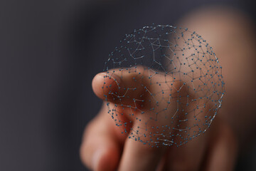 Close up of a hand holding a glowing digital network sphere, concept of connection, technology, or global network.