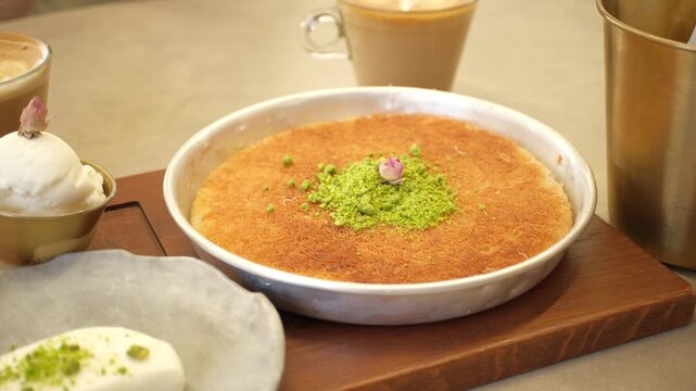 Traditional Middle Eastern knafeh dessert with pistachios and dried rose.