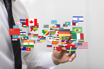 A man's hand interacting with flags of various countries, symbolizing globalization, diversity, and international relations. Suitable for concep