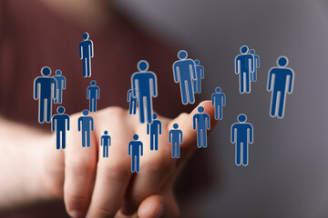 Hand pointing at floating digital people icons, symbolizing connection, teamwork, and social media. Perfect for