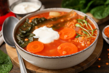 Tasty lentil soup served on wooden table, closeup