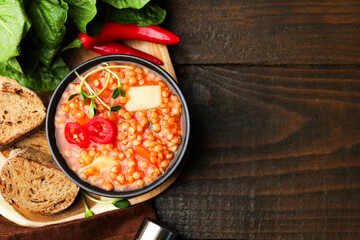 Delicious lentil soup with vegetables served on wooden table, flat lay. Space for text