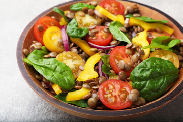Tasty salad with lentils and vegetables on grey table, closeup