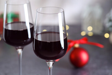 Glasses of red wine and Christmas decor on grey table, closeup. Space for text