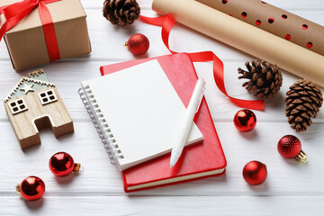 New Year aims. Blank planner, pen and festive decor on white wooden table © New Africa