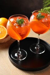 Refreshing spritzer cocktail with mint and oranges on wooden table, closeup