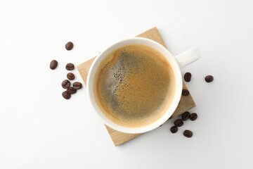 Cup of aromatic coffee and roasted beans on white background, flat lay