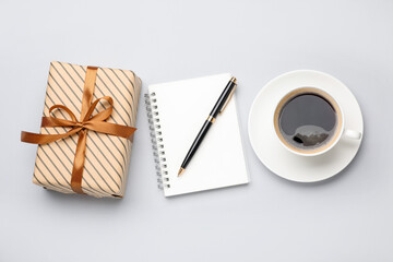 Obraz premium Beautiful gift box, notebook, pen and cup of coffee on white background, flat lay