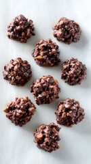 Obraz premium Multiple sweet chocolate crisp clusters lie scattered on clean white background, ready for dessert.