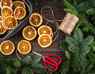 Natural craft with dried orange and fir branches. Shot from above.