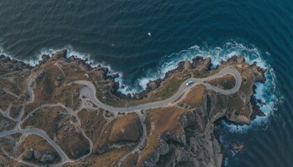 Aerial view of winding coastal road along dramatic cliffs and deep blue ocean