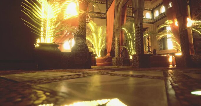 Warm light filters through the ornate architecture of a Moroccan interior, highlighting lush plants and intricate tile work. The inviting space creates a serene, luxurious atmosphere.