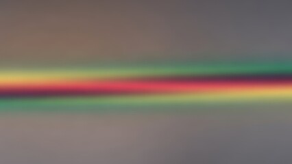 A colorful spectrum of light appears as a horizontal blur across a muted background