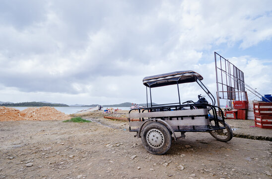 Motorized Tricycle Parked at a Coastal Area Under a Cloudy Sky