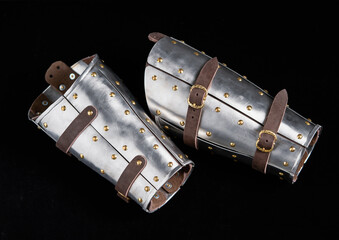 Medieval Armored Bracers with Leather Straps Against Black Background
