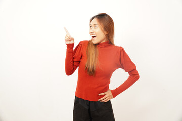 Happy young woman smiling widely while pointing sideways with one index finger, indicating direction or empty space.