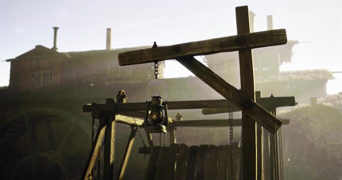 A rustic lantern dangles from a wooden post in an abandoned industrial area. Structures cast long shadows, evoking a sense of nostalgia and history.