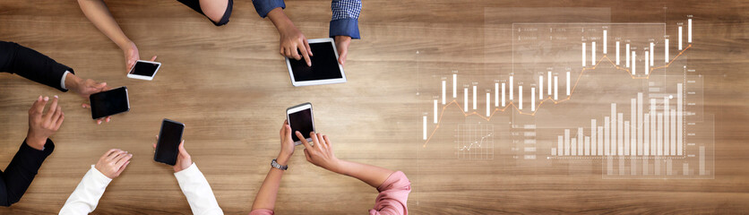 A captivating overhead view of diverse hands engaging with various digital devices on a wooden surface, emphasizing business growth and connectivity through data analysis. Scalp