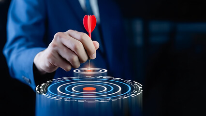 Businessman aiming a red dart at a digital target on a dark background