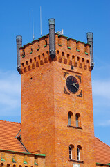 Historic brick clock tower with blue sky background, Swinoujscie, Poland
