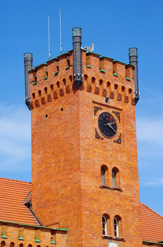 Historic brick clock tower with blue sky background, Swinoujscie, Poland