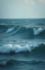 Obraz premium Ocean waves crash in blue water. Sea surface moves with white foam. Natural seascape with ripples and liquid motion. Background for calm or storm.