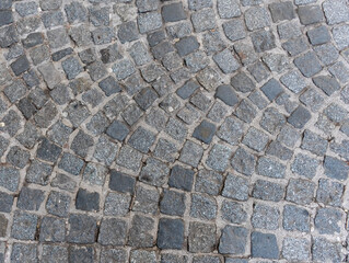 Wide stone paving made of granite cubes as traditional pavement for a historic street in a European city