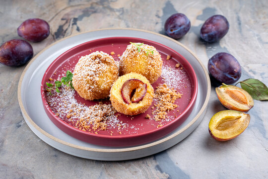 Traditional Austrian Zwetschgenkn&ouml;del - plum  dumpling stuffed with prune in a dough coat served with cinnamon butter crumbles