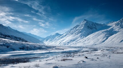 A majestic winter mountain landscape, showcasing snow-covered peaks and a serene valley under a bright blue sky