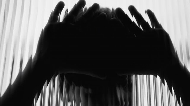 Child silhouette behind textured glass with hands forming tense shape conveying isolation despair and childhood trauma reflecting struggle with depression and mental illness