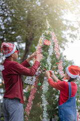 The children are celebrating Christmas and decorating the Christmas tree together.