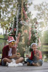 The children are celebrating Christmas and decorating the Christmas tree together.