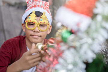 The children are celebrating Christmas and decorating the Christmas tree together.
