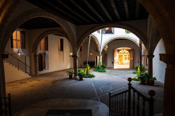 Historic courtyard with stone arches and soft lighting inside a traditional building. Elegant Mediterranean architecture.