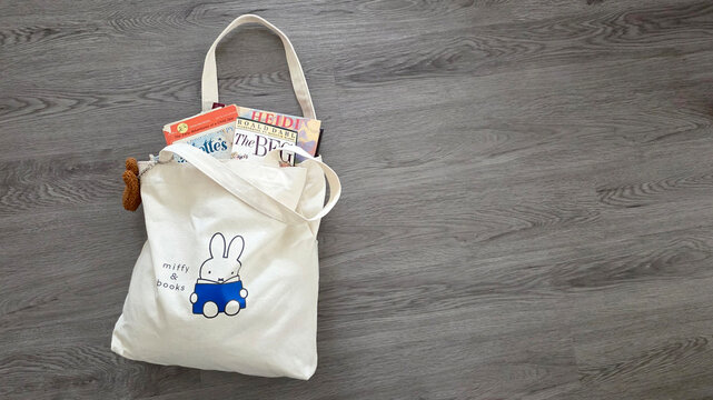 Miffy tote bag containing old children's books including The BFG and Heidi laying on a wood floor on December 12, 2025, Schaumburg, IL