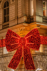 Christmas red bow decoration on historic building facade
