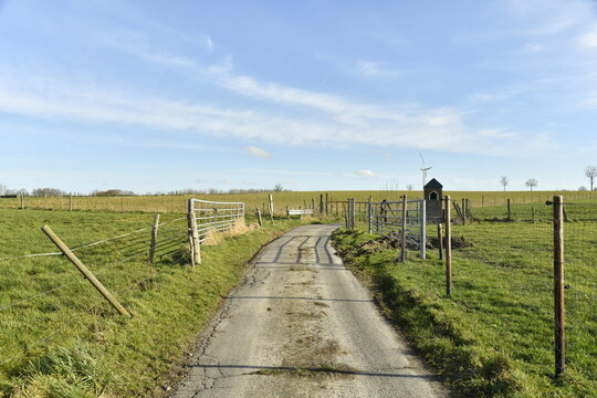 Chemin en bitume entre les champs sous un ciel bleu &agrave; Ghislenghien (Ath)