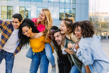 Group of cheerful multiracial friends posing outdoors, laughing and smiling. Friendship, youth, and joyful lifestyle concept.