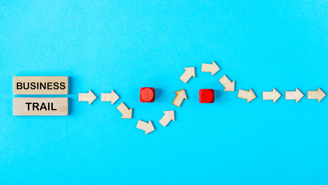 Avoiding obstacles while running a business, the concept of difficulties encountered by an entrepreneur. The Business Trail sign and wooden arrows avoiding obstacles on the way to the goal.