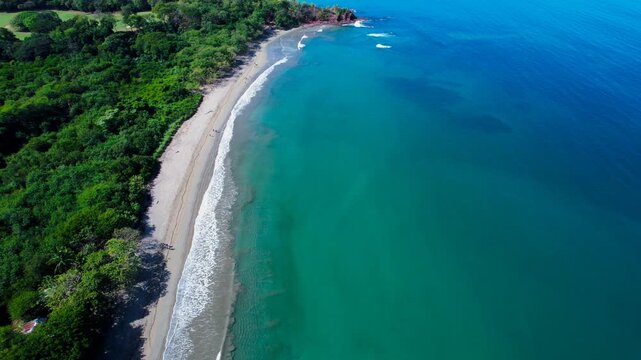 Aerial View of Tropical Beach and Turquoise Ocean Along Lush Coastline