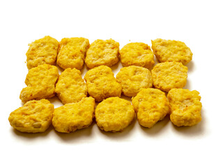 A pile of golden fried chicken nuggets on white background. The nuggets are golden brown and appear to be crispy. Fine popular poultry product.