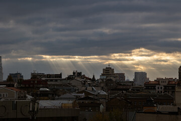 Kyiv city center skyline with dramatic sky and sun rays over historic roofs