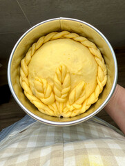 Raw braided sweet bread dough in round pan