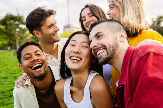 Multiracial group of young friends having fun together outdoors in summer. Millennial student people laughing walking in city street enjoying day off. Youth community and friendship concept. - Powered by Adobe