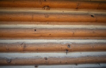 Obraz premium Natural wood texture background from stacked logs of a rustic cabin wall. Horizontal rough timber pattern creates cozy, warm, organic surface for design concepts.