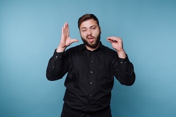 Fototapeta premium Man makes gestures while speaking in front of a blue background during a presentation or conversation setting