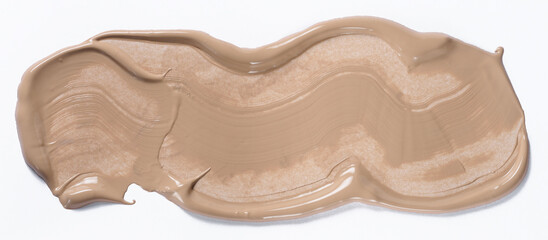 A broad brushstroke of nude or beige foundation with a distinct wave texture from the brush, glossy finish